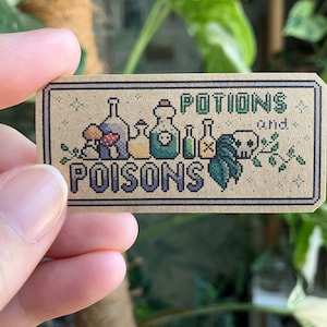 May include: A brown card with the text "Potions and Poisons" in a pixelated font. The card features a row of five potion bottles, two mushrooms, a skull, and a leafy branch.