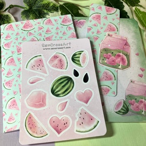 Puede incluir: Un conjunto de papelería con temática de sandía que incluye una libreta con estampado rosa y verde, un marcapáginas con estampado rosa y verde y una hoja de pegatinas con rodajas de sandía, corazones y una caja de zumo de sandía. Las pegatinas están sobre un fondo rosa. La libreta y el marcapáginas tienen el texto "SenCroArt" y "www.sencroart.com".