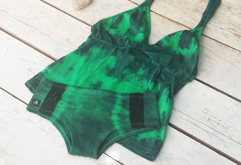 May include: Green tie-dye halter top and matching underwear with black lace trim. The top has a deep V-neckline and the underwear has a high-cut leg.