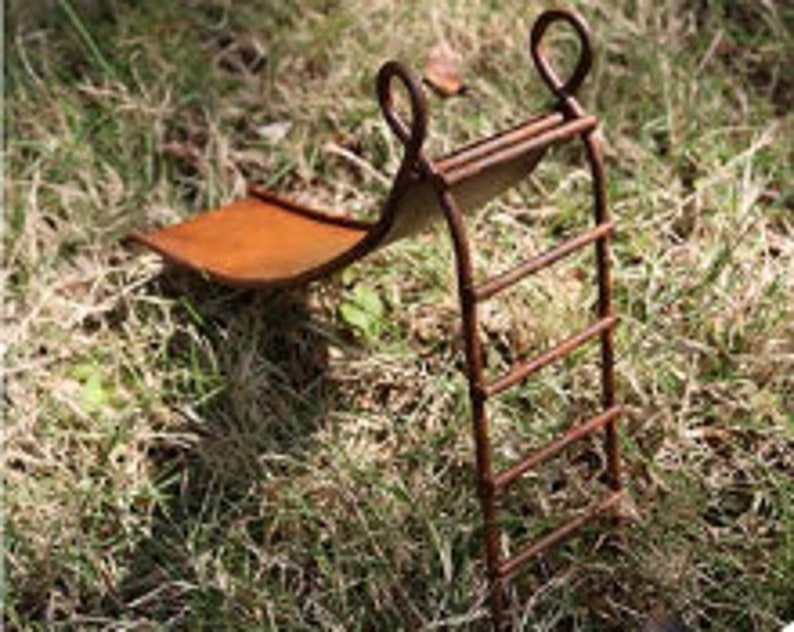 May include: A miniature rusty metal slide and ladder set for a fairy garden or miniature landscape. The slide is made of metal and has a rusty finish. The ladder has five rungs and is also made of metal.