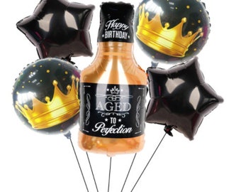 May include: A set of 7 black and gold foil balloons for a birthday party. The balloons include a bottle shaped balloon with the text "Happy Birthday Aged to Perfection", a crown shaped balloon, and 5 star shaped balloons.