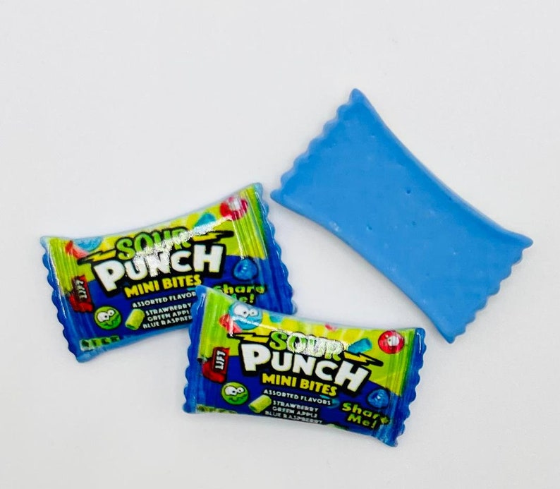 May include: Two blue and green Sour Punch Mini Bites candy packages with the text "Sour Punch Mini Bites" and "Share Me!" on the front. There is also a blue candy wrapper.