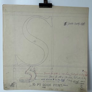 Può includere: Disegno architettonico vintage della lettera "S" a matita su carta invecchiata, tenuto da una clip metallica. Include note manoscritte, misure e il testo "10 PT BOOK PRINT ITALIC".