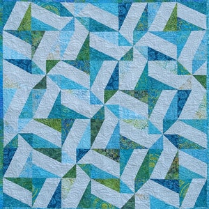 Puede incluir: Un edredón cuadrado con un patrón geométrico. El diseño presenta triángulos en azul claro, turquesa y verde sobre un fondo blanco. El edredón tiene un patrón repetitivo y un borde turquesa.