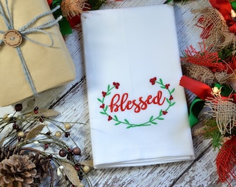 Puede incluir: Toalla de cocina blanca con bordado rojo de una corona con la palabra "blessed" en el centro.