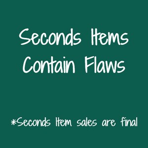Puede incluir: Texto blanco sobre fondo verde oscuro que dice "Seconds Items Contain Flaws" y "*Seconds Item sales are final".