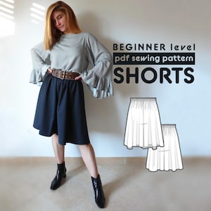 Puede incluir: Una mujer con una blusa gris y pantalones cortos negros con un cinturón marrón. La imagen también muestra un patrón de costura para pantalones cortos etiquetado como "BEGINNER level pdf sewing pattern SHORTS".