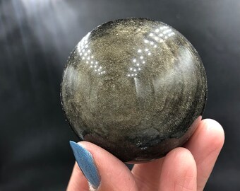 Goldglänzende Obsidiankugel auf geätztem Holzständer, schwarzes vulkanisches Glas, poliertes natürliches Mineralexemplar, Felsen, Mineralien, Mexiko, Kristallliebhaber