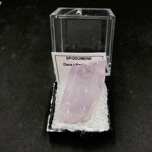 May include: A clear plastic display case with a purple crystal labeled "SPODUMENE Dara-i-Pech"