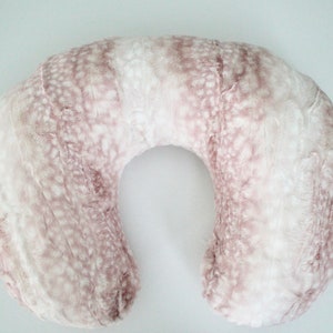 May include: A U-shaped pregnancy pillow with a soft, plush pink and white faux fur cover.