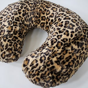 May include: A U-shaped pregnancy pillow with a leopard print cover.