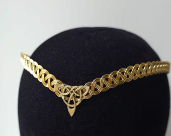 May include: A gold-toned wire circlet featuring a woven, braided band design that tapers to a point at the center. The focal point is a triangular Celtic triquetra knot ornament made of twisted wire, securely attached to the front of the band.