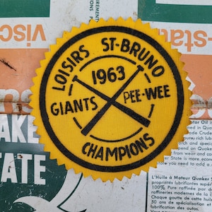 Puede incluir: Parche bordado amarillo y negro con el texto "Loisirs St-Bruno 1963 Pee-Wee Giants Champions".