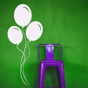 Balloon wall decal featuring three floating balloons with curling strings, perfect for a playful and cheerful kid's space. Vinyl decals featuring a trio of helium-like balloons that appear to be floating together. Displayed as door sign decals, window stickers, and various examples of balloon wall decor.