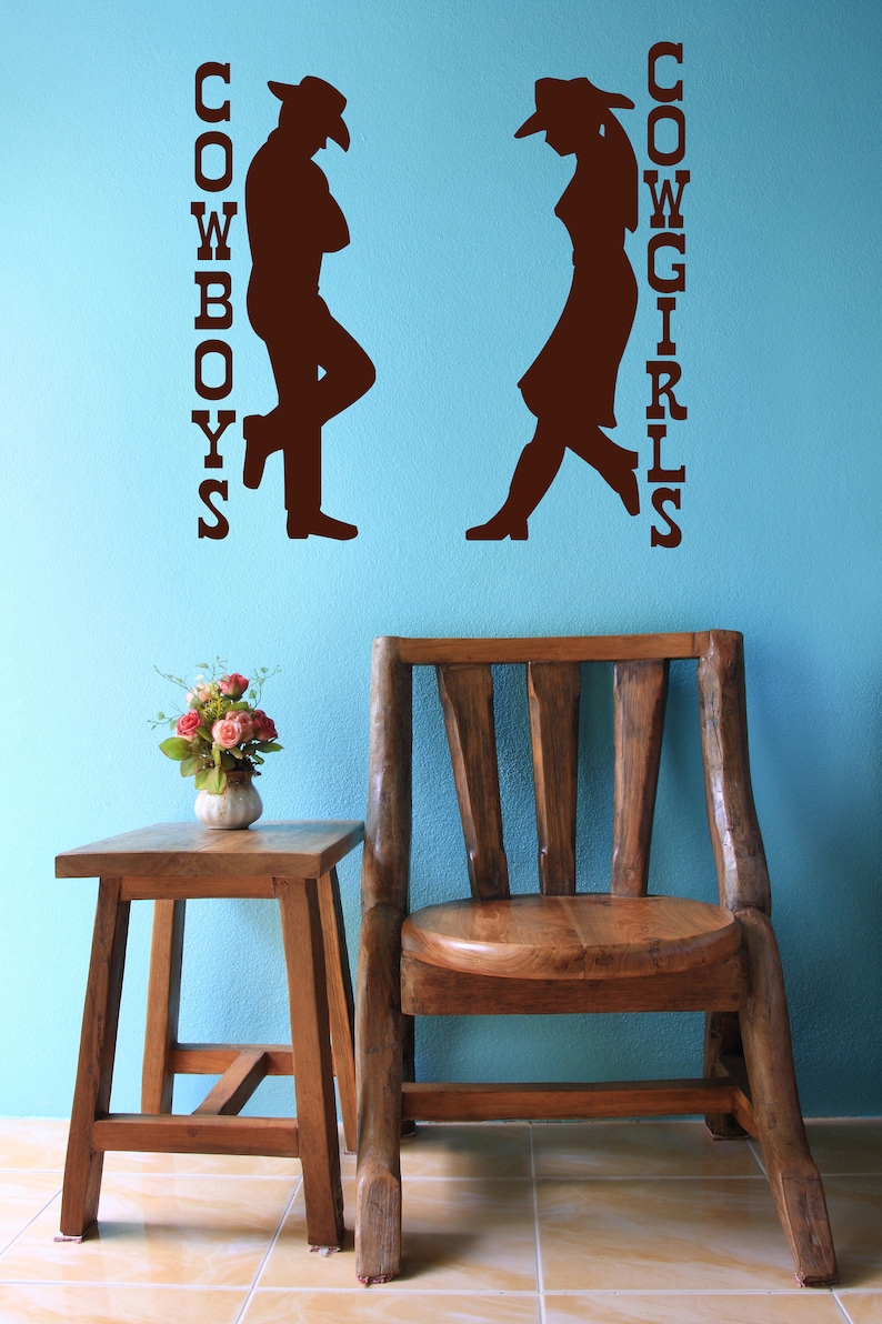 Bathroom wall decal featuring cowboy and cowgirl artwork, blending western decor with functional restroom signage.