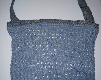 May include: A blue crocheted tote bag with a long strap. The bag is made of a woven material and has a light blue color.