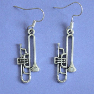 May include: A pair of silver-toned trombone earrings. Each earring features a detailed trombone design with a bell and slide.
