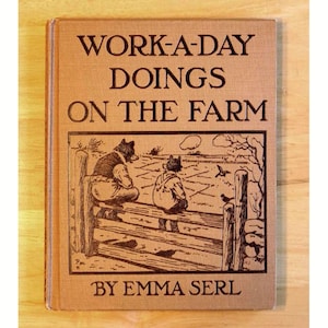 May include: A vintage book titled "WORK-A-DAY DOINGS ON THE FARM" by Emma Serl. The cover is tan with black text and a sepia-toned illustration of two figures on a fence overlooking a farm scene.