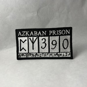 May include: Black and white embroidered patch with the text "Azkaban Prison" and the number "Y390".