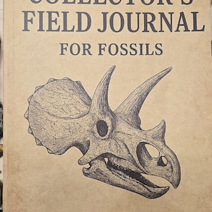 May include: A field journal for fossils with the text "COLLECTOR'S FIELD JOURNAL FOR FOSSILS" and "DINOSAUR21". The cover features a detailed illustration of a Triceratops skull in black ink on a tan background.