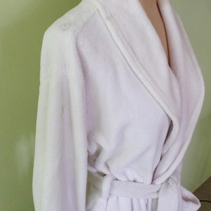 May include: White plush robe with a shawl collar and a tie belt.
