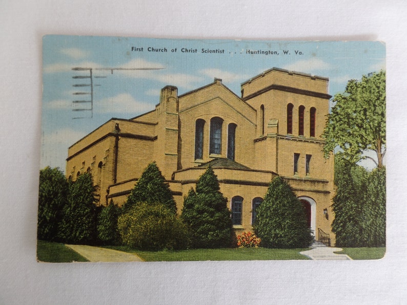 May include: A vintage postcard showing the First Church of Christ Scientist in Huntington, West Virginia. The building is constructed from yellow brick with a tall tower and a large arched entrance.