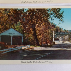 May include: Vintage postcard featuring a scenic view of Cheat Bridge. The image shows a covered bridge with a road leading through it, surrounded by trees with autumn foliage. A small building with garage doors is on the left. The text "Cheat Bridge Yesterday and To-day" is at the bottom.