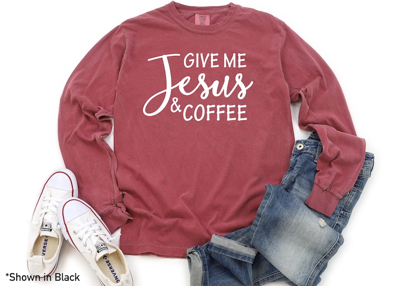 May include: A long-sleeved t-shirt with a maroon color featuring the text "Give me Jesus & Coffee" in white.