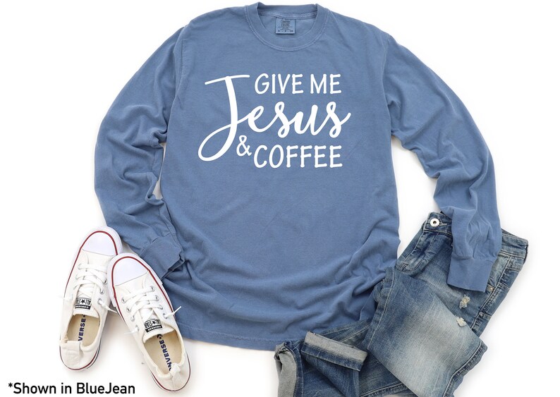 May include: A blue long-sleeved t-shirt with the text "Give Me Jesus & Coffee" in white lettering.