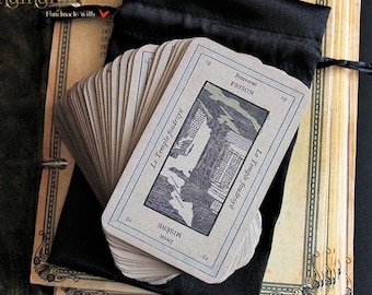 May include: A deck of tarot cards with a black velvet bag. The top card shows a drawing of a building with the text "Le Temple foudroyé" and "Droit MISÈRE" on the left side and "Renversé PRISON" on the right side.
