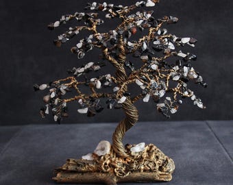 May include: A handcrafted wire tree sculpture with a twisted trunk and branches adorned with black, white, and brown gemstones. The tree sits on a decorative base, creating a unique home decor item.