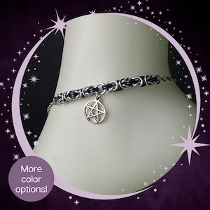 May include: A silver chain bracelet with a pentagram charm. The chain is made of interwoven silver and black leather.