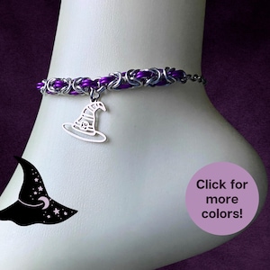 May include: A purple and silver chainmail anklet with a witch hat charm. The anklet is on a foot, with a purple background. A graphic of a witch hat with stars and a moon is on the left. Text on the right says "Click for more colors!"