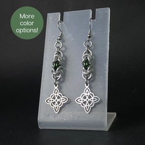 May include: Silver earrings with a green bead and a Celtic knot design.