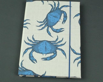 Blue and white notebook with lined colored tabs and printed large crabs