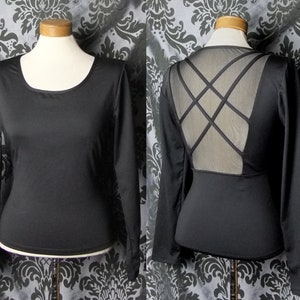May include: Black long-sleeved shirt with a mesh panel on the back featuring a criss-cross design.