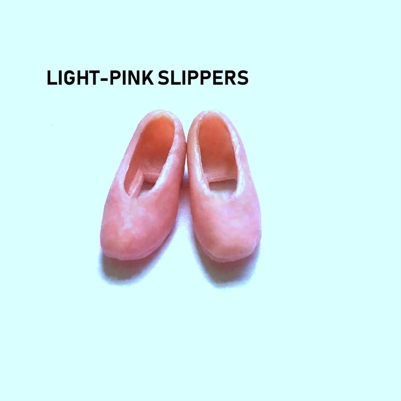 May include: A pair of light pink slippers. The slippers are made of a soft, pliable material and have a simple, classic design.