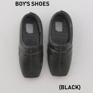 May include: A pair of black plastic doll shoes.  "BOY'S SHOES (BLACK)" is printed below the shoes.