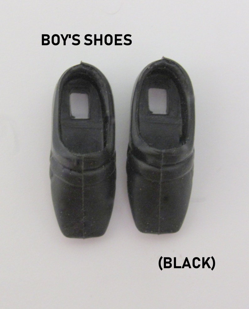May include: A pair of black plastic doll shoes.  "BOY'S SHOES (BLACK)" is printed below the shoes.