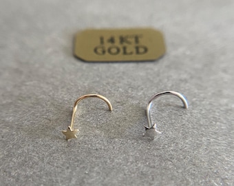 May include: Two nose rings with a star design. One is gold and the other is silver.