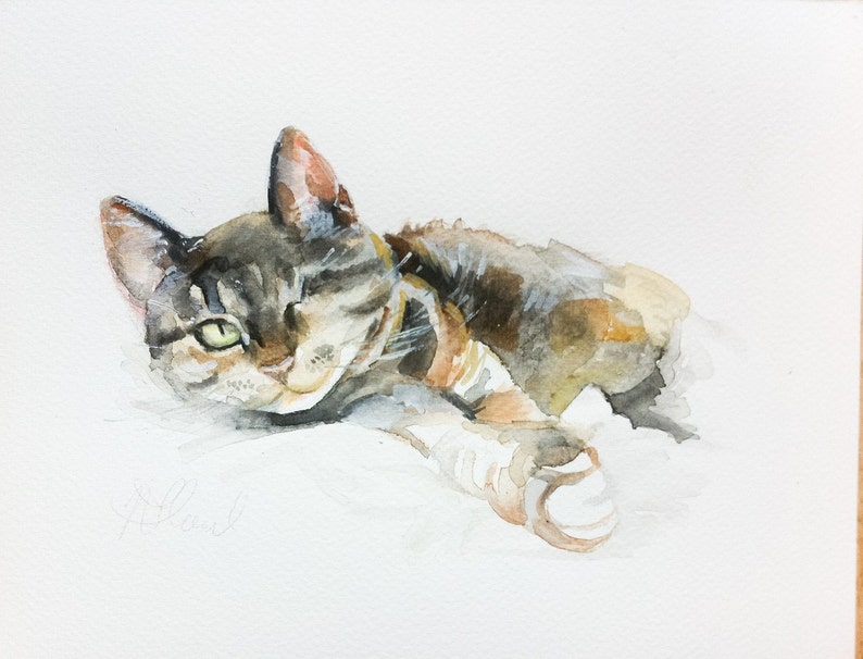 May include: Watercolor painting of a tabby cat lying down with one eye open. The cat is painted in shades of brown, gray, and white.