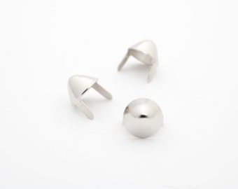 May include: Three silver metal rivets, two with pointed tops and one with a rounded top.