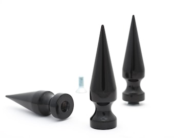 May include: Three black metal spikes with a pointed tip and a threaded base. The spikes are designed for use as motorcycle accessories.