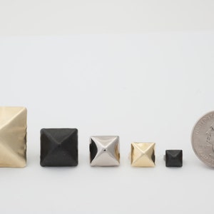 May include: Assortment of pyramid-shaped metal studs in gold, silver, and black. The studs are arranged in order of size, with the largest stud on the left and the smallest stud on the right. A US quarter is included for scale.