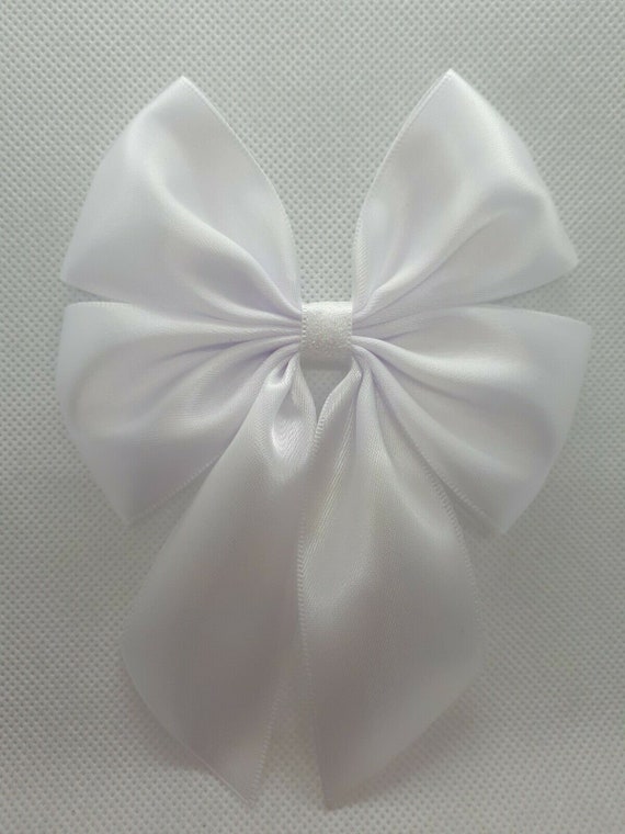 Pink, blue and white satin ribbon bows on wooden background