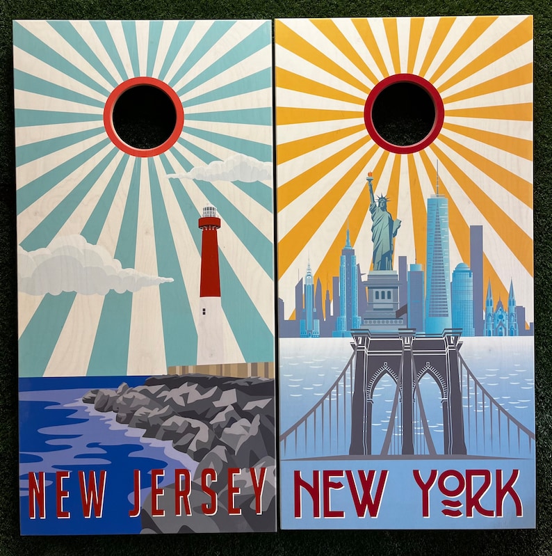 May include: Two wooden signs with a sunburst design. The left sign says "New Jersey" and features a lighthouse. The right sign says "New York" and features the Brooklyn Bridge.