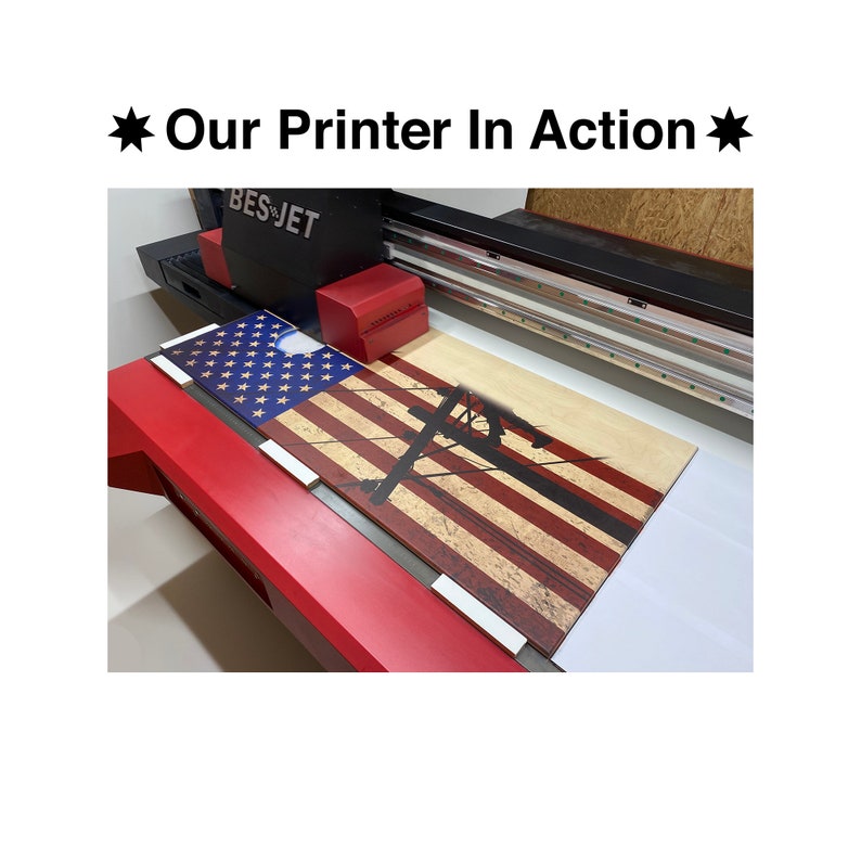 May include: A large format printer printing a wooden sign with an American flag design and a silhouette of a person working on a power line. The printer is labeled "BES-JET".
