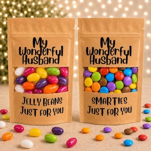 Könnte beinhalten: Zwei braune Papiertüten mit Sichtfenstern, die bunte Süßigkeiten enthalten. Die linke Tüte ist mit My Wonderful Husband Jelly Beans Just For You beschriftet. Die rechte Tüte trägt die Aufschrift My Wonderful Husband Smarties Just For You.