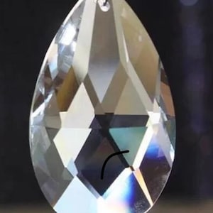May include: A clear crystal teardrop prism with a faceted design. The prism has a silver metal loop at the top for hanging.