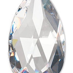 May include: A clear crystal teardrop pendant with a faceted design. The pendant has a hole at the top for hanging.